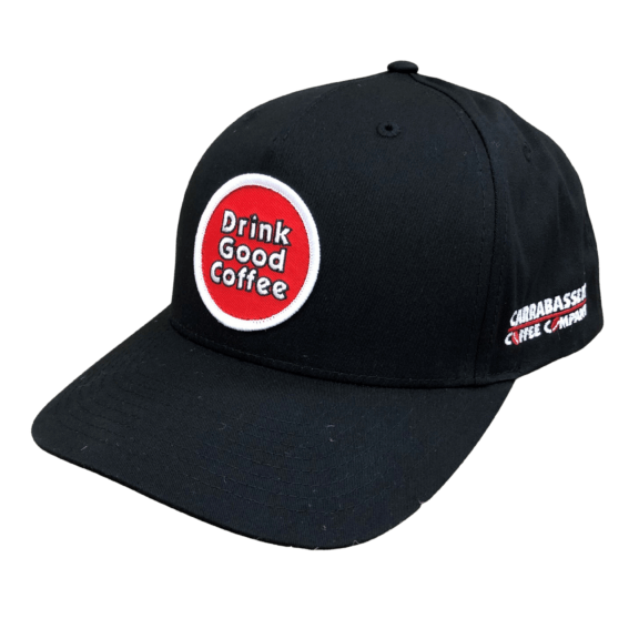Photo of a black baseball cap with red circle on the front. Inside the circle are the words: Drink Good Coffee. On the side of the hat are the words: Carrabassett Coffee Company.