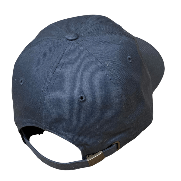 The back side of the gray unstructured baseball hat. This photograph shows the metal clasp fastener on the back of the hat.