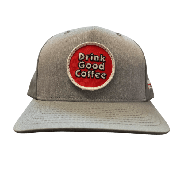 Photo of a 2-tone gray baseball cap with red circle on the front. Inside the circle are the words: Drink Good Coffee. On the side of the hat are the words: Carrabassett Coffee Company.