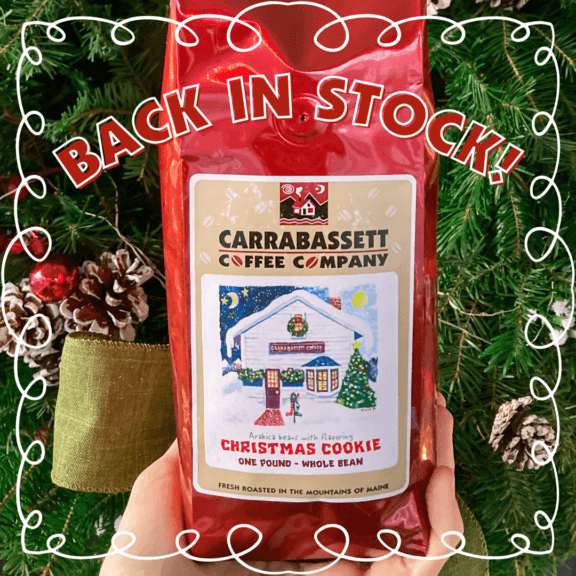 A red coffee bag with the Christmas Cookie label art (in front of a wreath). The words "Back in Stock" are across the top of the image.