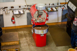photo showing red coffee roaster and side of another coffee roaster from above